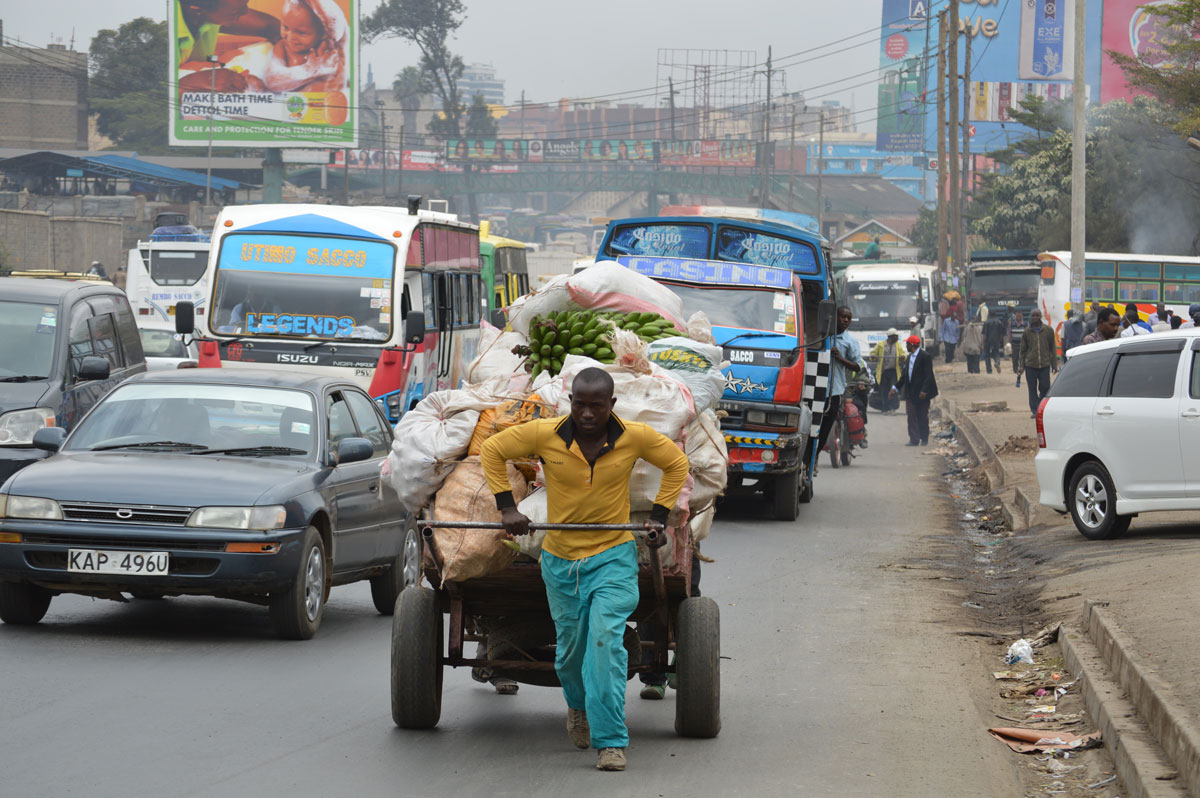 man pulling cart through streets